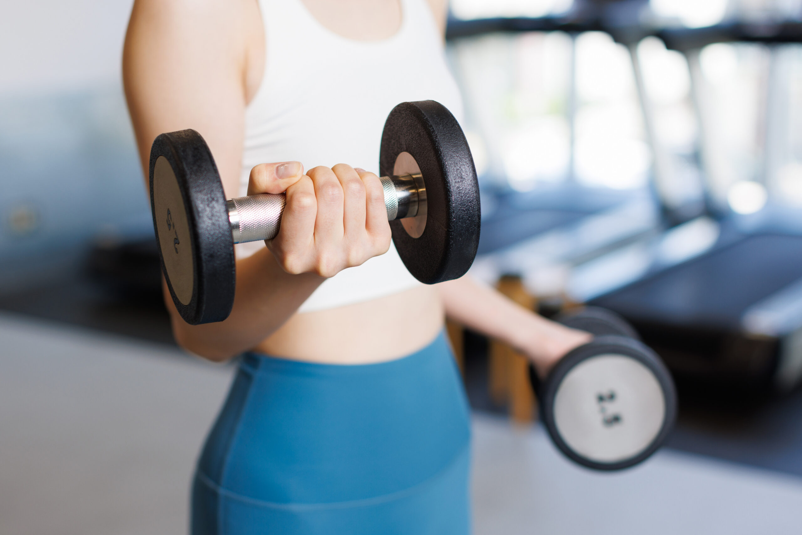 Woman training with dumbbells at gym