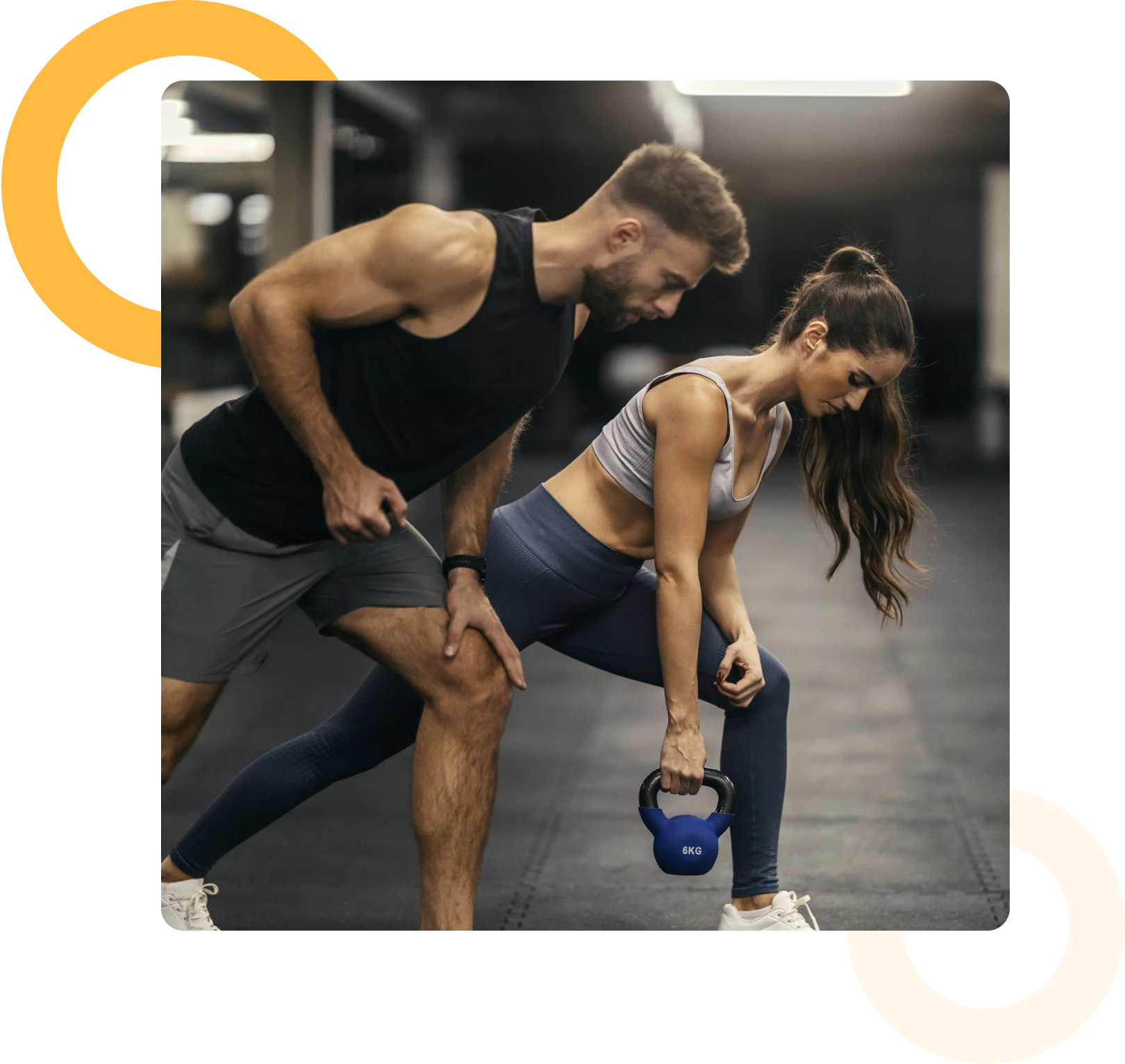 A man coaches a woman performing a kettlebell row exercise in a gym setting.