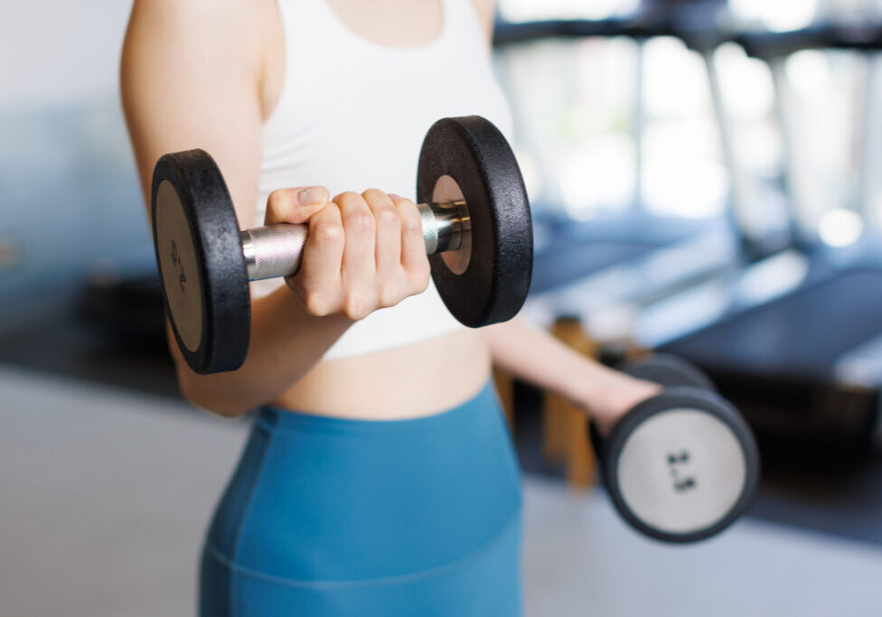 Woman training with dumbbells at gym